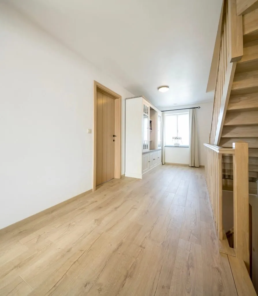 A calm treatment room with natural light and warm neutral materials
