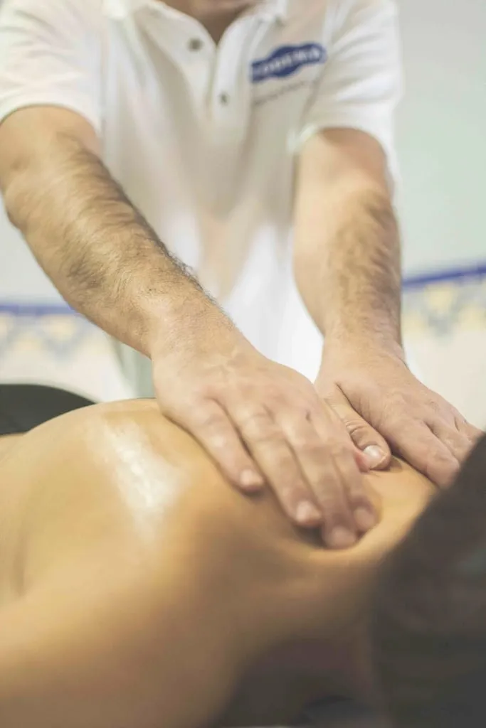 A therapist applying pressure along a client's back during treatment